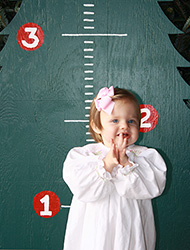 Children posing with the growing tree to mark another year of love and memories at the Kiser Christmas Tree Market