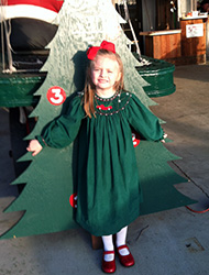 Children posing with the growing tree to mark another year of love and memories at the Kiser Christmas Tree Market